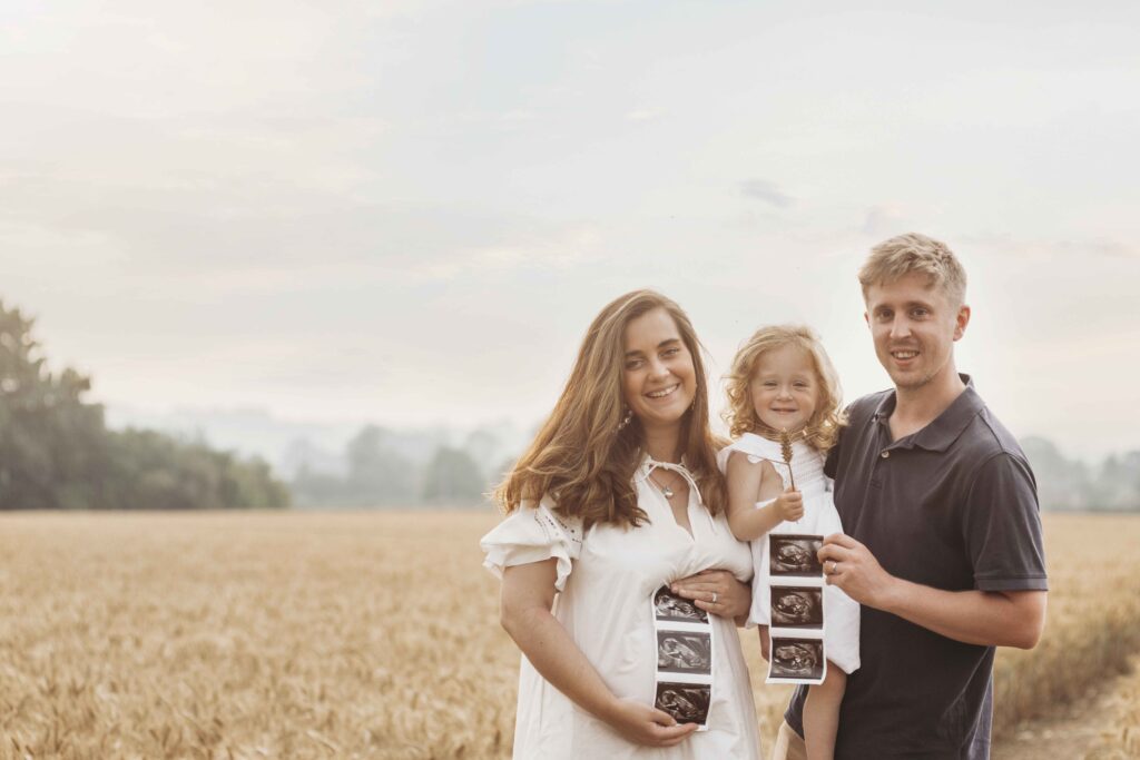 Twin pregnancy reveal photoshoot in a wheat field